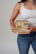 Beige fabric-lined jewelry case held open with earrings in cover and rings in bottom section