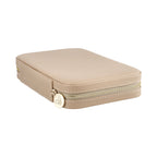 Pale pink jewelry case with gold logo zipper, rounded corners, and compact design
