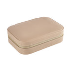 Compact pale pink jewelry case with rounded corners and gold logo zipper, displayed on white background