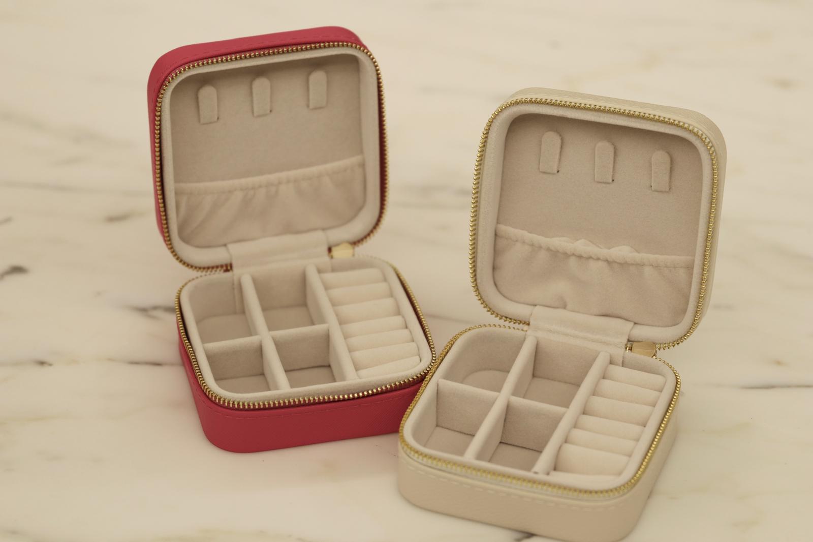 Small red jewelry box and beige jewelry box for sustainable jewelry on marble table